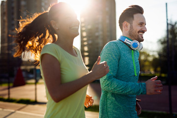 Young fitness couple running in urban area