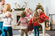 © LIGHTFIELD STUDIOS - rear view of kids running to hug grandparents during christmas eve at home