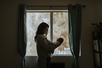 Wall Mural - mother holding her baby indoors