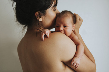 Wall Mural - naked mother holding her infant baby