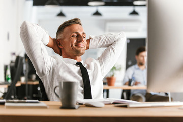 Wall Mural - happy business man sitting in office working with computer have a rest.