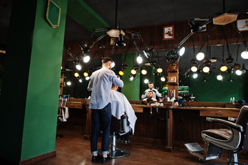 Handsome bearded man at the barbershop, barber at work.