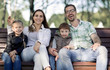 © ASDF - portrait of a happy family sitting on a Park bench