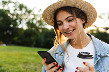 Poster - Lovely young girl in summer hat sitting outdoors