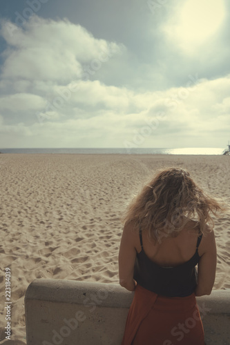 Nice Curly Blonde Hair Girl Back View Against A Beautiful Beach On