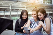 © gballgiggs - Happy and smiling women traveler is making a selfie in the city,Beautiful girl walking on the streets,Multiracial female friends