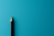 Black Pencil On Blue Paper Background. - Business Concept.