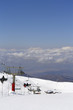 © Olga - White snow-capped mountain slopes with skiers and blue sky with white clouds