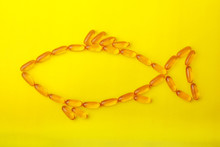 Fish Form From Fish Oil Capsules On A Yellow Background With Copy Space