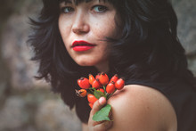 Sexy Beautiful Pretty Brunette With Red Lipstick With Red Rose Hips In Hand