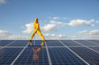 Clean Energy Concept.Reflection of worker are cleaning solar panel against white clouds and blue sky.
