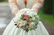 Beautiful bride in white wedding dress holding bouquet