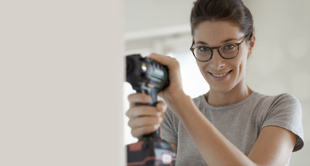 Wall Mural - Woman using a drill and working in her new house