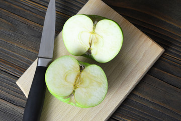 Wall Mural - Apple cut in half on wooden background