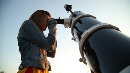 Wall Mural - young woman looking at the sky with astronomical telescope.