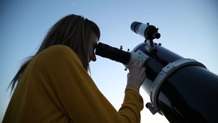 Wall Mural - young woman looking at the sky with astronomical telescope.
