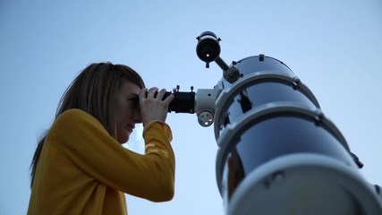 Wall Mural - young woman looking at the sky with astronomical telescope.
