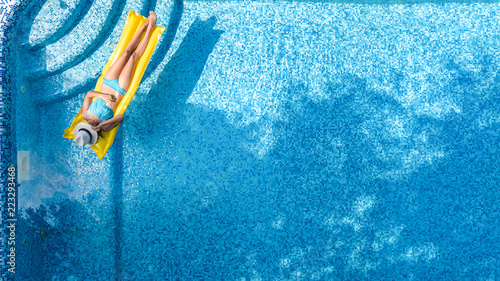 Zdjęcie XXL Piękna młoda dziewczyna relaks w basenie, pływa na materac i ma zabawy w wodzie na rodzinne wakacje, tropikalny ośrodek wypoczynkowy, widok z lotu ptaka drone z góry