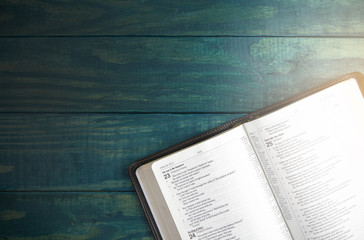 Poster - Holy Bible on a Blue Wooden Table Out for Studying