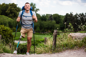 Wall Mural - Overjoyed young man with prosthesis trying Nordic walking