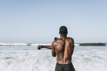 Wall Mural - Fit man stretching at the beach