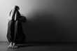 Leinwandbild Motiv Teenager girl with depression sitting alone on the floor in the dark room.  Black and white photo