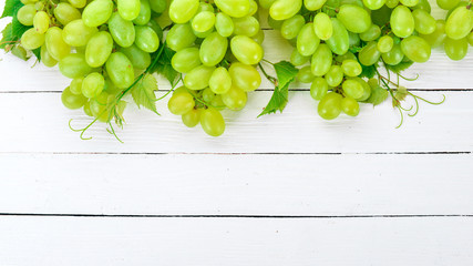 Grape. Fresh white grapes on a white wooden background. Top view. Free space for text.