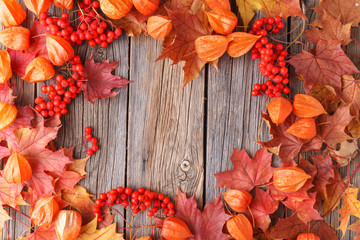 Wall Mural - Autumn pattern golden maple leaves on wooden background