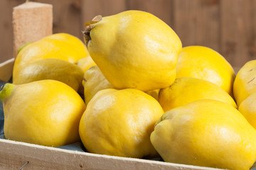 Ripe Quince Fruits In Wooden Box.