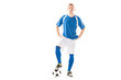 © LIGHTFIELD STUDIOS - confident young soccer player standing with hands on hips and looking at camera isolated on white