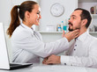 © JackF - Male visitor consulting smiling woman doctor in hospital