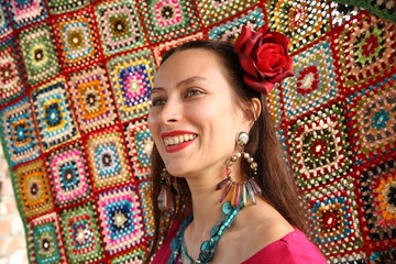  Beautiful gypsy woman in red with a red rose in her head on a bright background