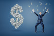© gearstd - A happy businessman throws and catches money near a large dollar sign made of banknotes.