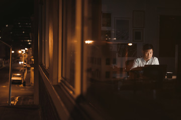 Wall Mural - Asian businessman working late in the city at night 