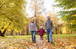 © Syda Productions - family, season and people concept - happy mother, father and little daughter walking at autumn park