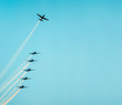 Airplane flying up separating from the squad. Airplanes flying together leaving a smoke trail behind. Aerial acrobatics airplanes. Clear blue sky day. Large space for text.