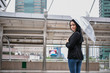 © S photographer - Holiday concept. Young businesswoman walking in the rain. Beautiful young woman looking at the rain.