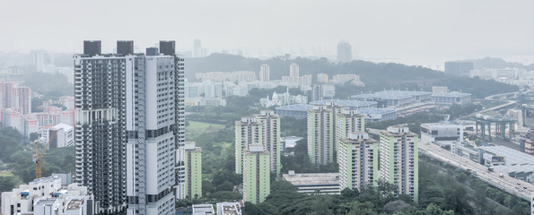 Wall Mural - Panorama typical aerial view of residential building skyscraper HDB at the South of Singapore city center. Modern cityscape surrounded by green trees under haze sunset