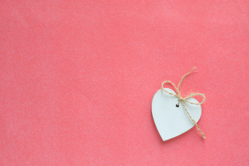 White wooden heart on pink backgroun