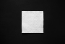 Blank White Paper Napkin On Black Background With Copy Space. Flat Lay.