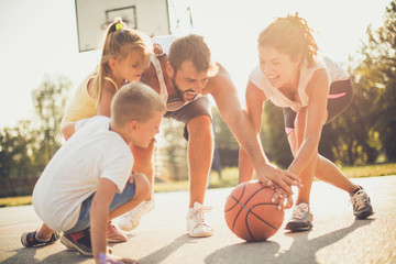 Wall Mural - Family outside playing basketball together.