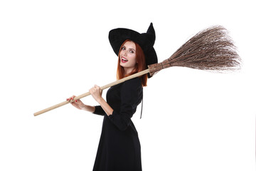 Beautiful redhaired woman in halloween costume with broom isolated on white background