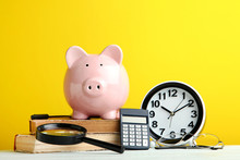 Pink Piggy Bank With Retro Books, Calculator And Clock On Yellow Background