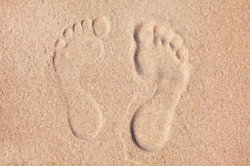 Two Footprints in sand at the Beach