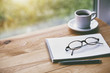 © Ivan Kruk - cup of fresh morning coffee with paper notebook, glasses and pen for writing