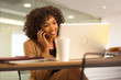 © Mark Adams - Millennial  businesswoman using laptop computer while talking on phone.