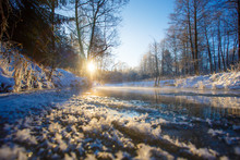 Bright Sun Rising Over Frozen River In Winter. Rural Landscape