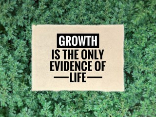Wall Mural - Motivational and inspirational quote - Growth is the only evidence of life. Blurred styled background.