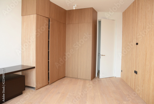 Fotografia Wood Flooring with modern wooden wall, room door, table and wooden wardrobe