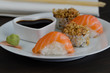 Set of sushi and rolls, wasabi, ginger and soy  with chopsticks on wooden table. Japanese food background.